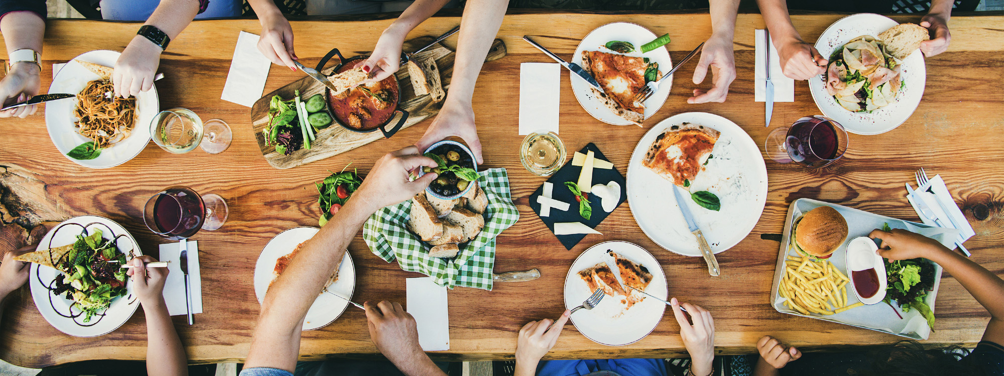 many people that support local dine together around a large table filled with food