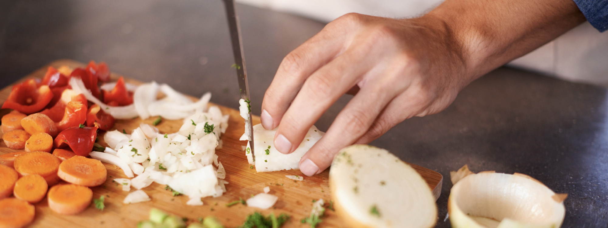 cook slicing onion and other vegetables, one of many jobs at prairieland market