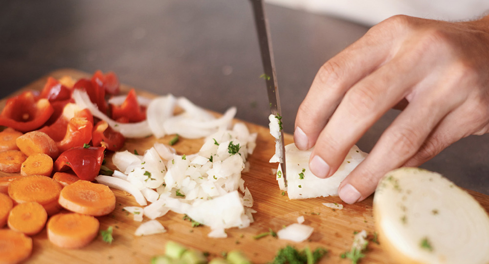 cook slicing onion and other vegetables, one of many jobs at prairieland market