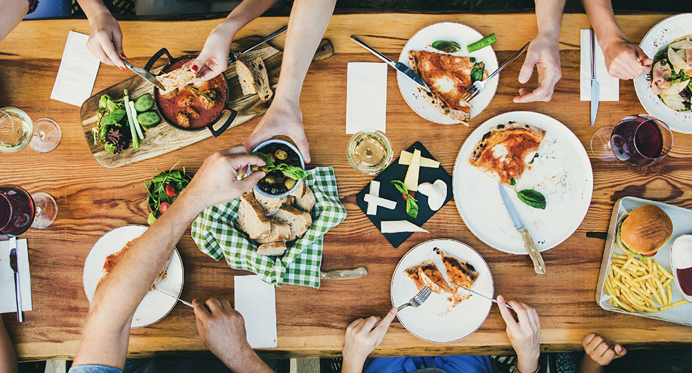 many people that support local dine together around a large table filled with food