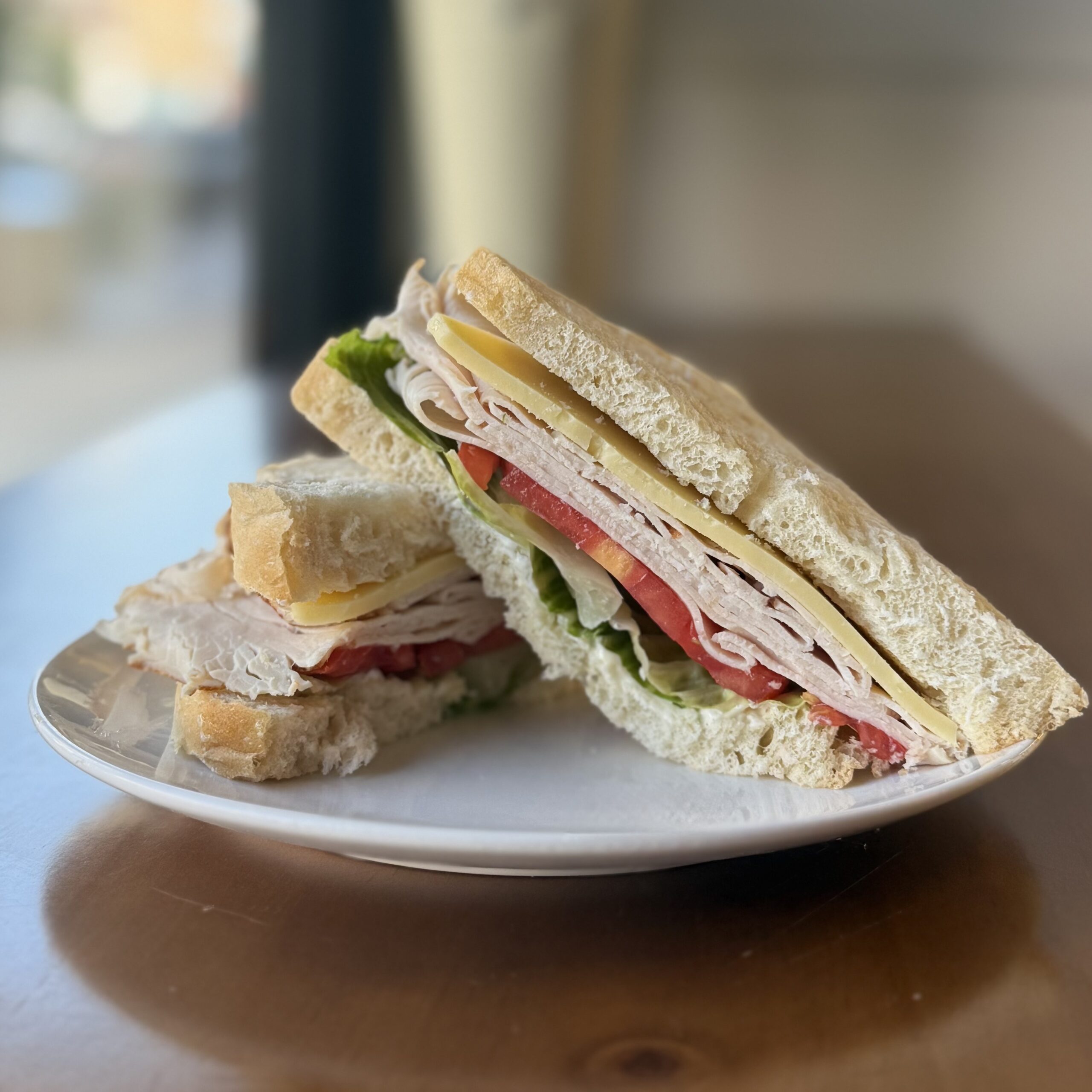 turkey sandwich with cheese, lettuce and tomato