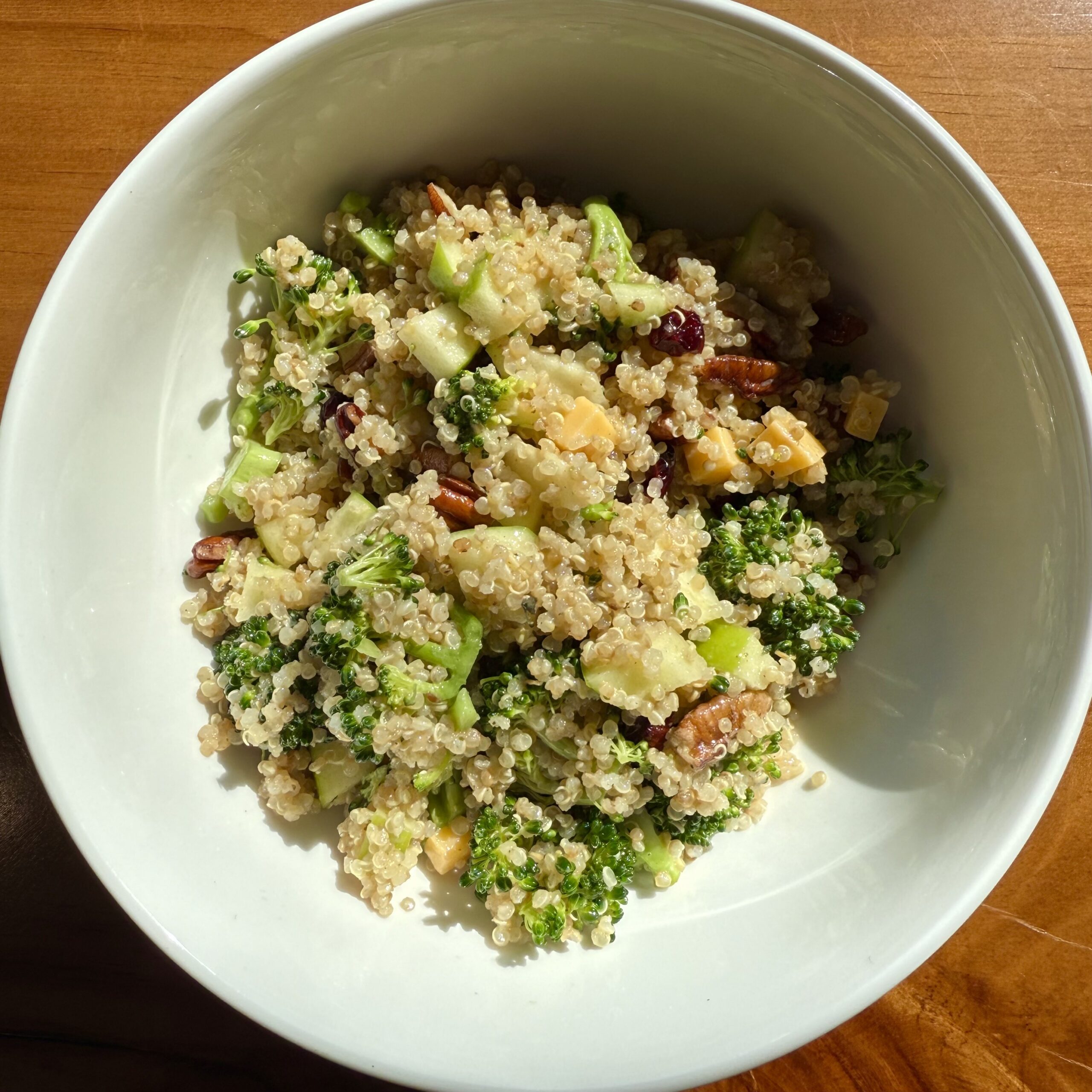 quinoa salad with broccoli, cranberries, cheese, walnuts and apples