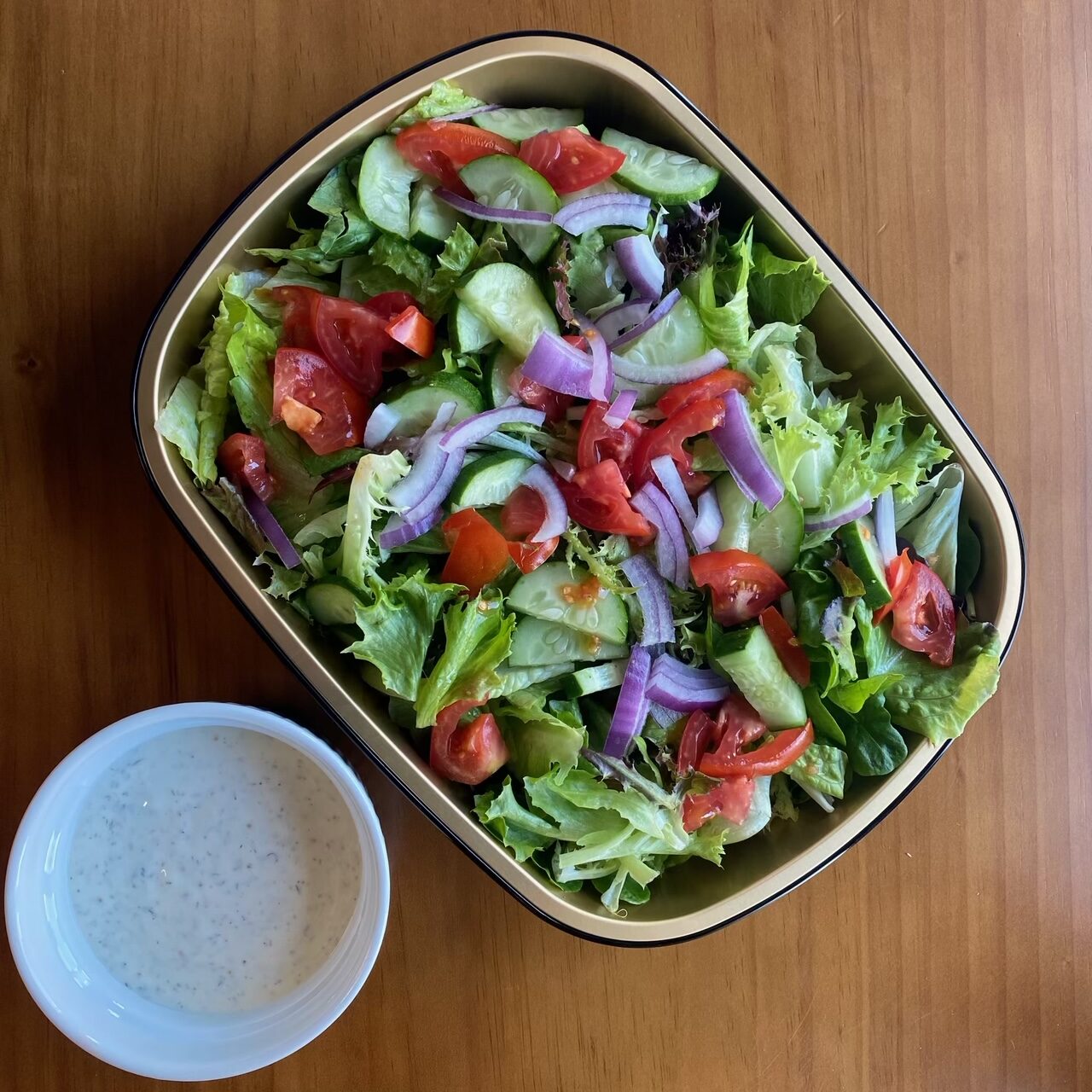 large salad with tomatoes, red onion, cucumber and ranch