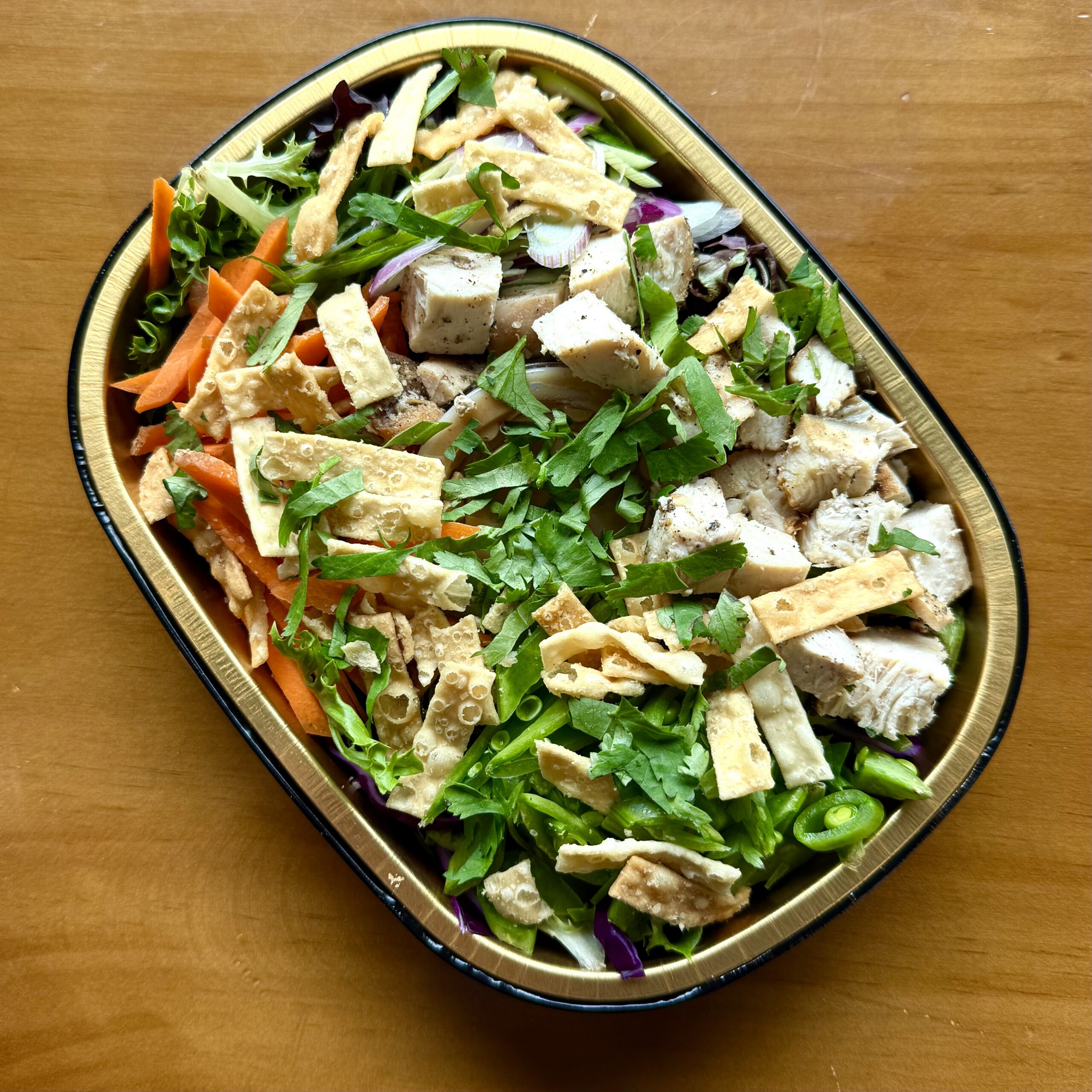 salad with carrots, chicken, cabbage, snap peas, cilantro and wonton strips