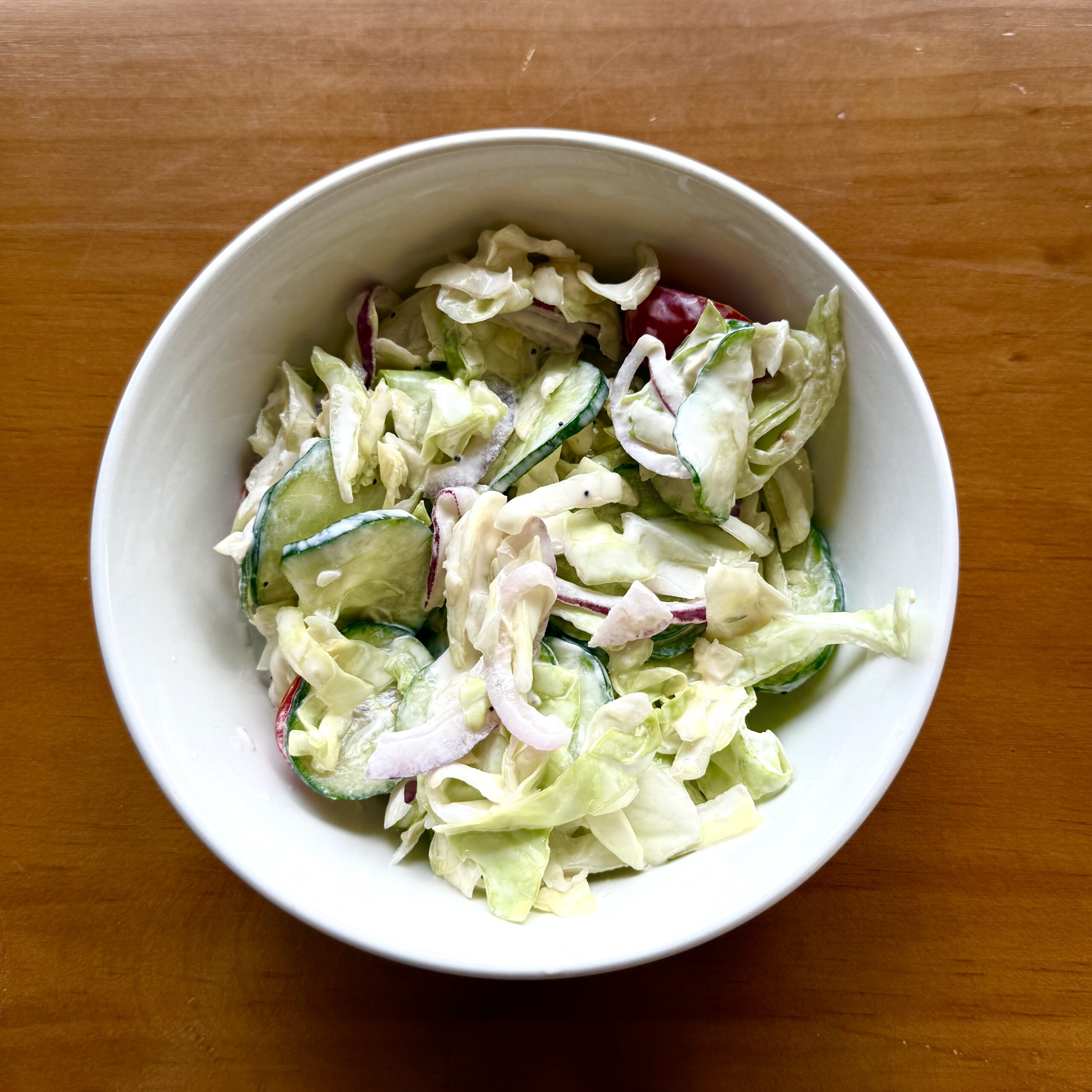 cabbage slaw with cucumber, tomato and onion in creamy sauce
